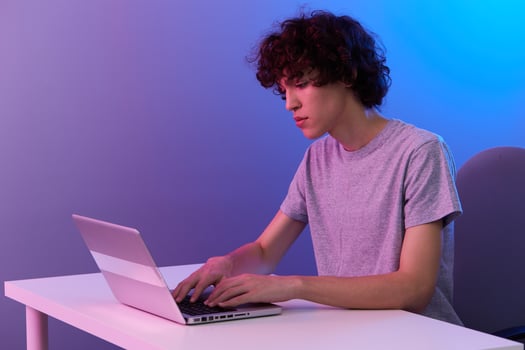guy cyberspace playing with in front of a laptop violet background photo