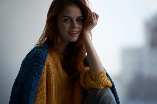 pretty woman sitting near the window covered with a blanket rest comfort photo