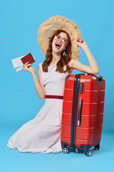 cheerful woman in a hat sits on the floor with a suitcase travel destination photo