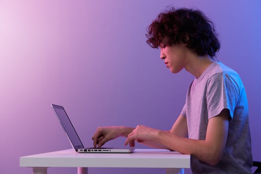 man cyberspace playing with in front of a laptop violet background photo