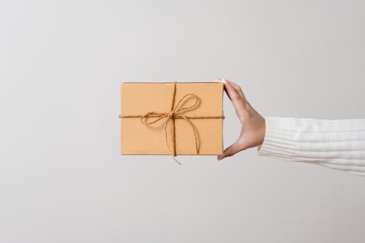 Woman hands holding present box with a ribbon bow. Concept of gift  box minimalist style. Showing brown cardboard boxes delivery someone in special occasions or parcel deliver service. photo