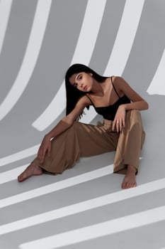 sexy woman sitting on the floor indoors spreading her legs and gesturing with her hands photo