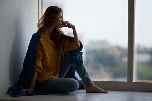 woman sitting on the windowsill with a blue plaid smile photo