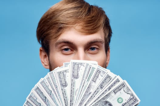 man with wad of money finance official blue background photo