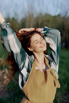 A young woman in work clothes and wearing an apron outdoors enjoying the sunset and relaxing after a hard day's work photo