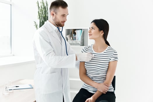 a doctor with a stethoscope examines a patient in a hospital photo
