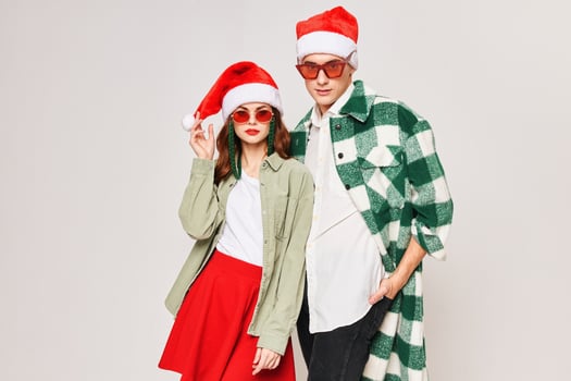 Young couple wearing sunglasses Santa hat Christmas winter holiday fashion photo