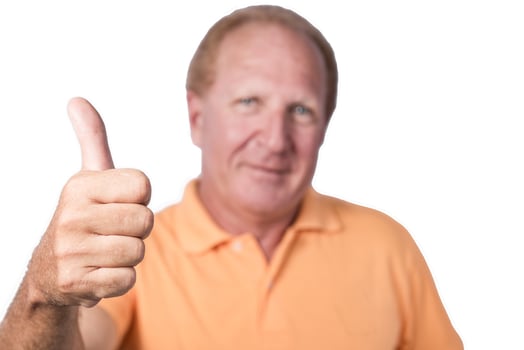 Handsome old man in orange polo-shirt shows thumb up photo