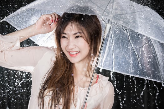 Happy girl holding transparent umbrella among the rain photo