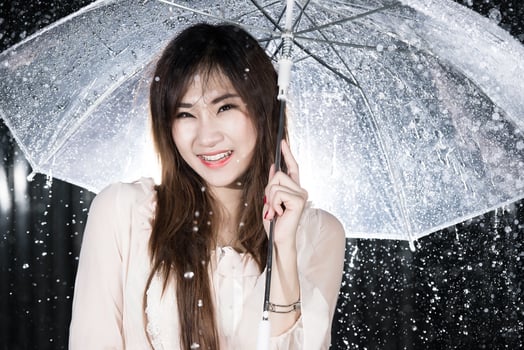 Happy girl holding transparent umbrella among the rain photo