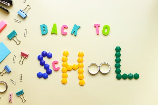 Flat lay inscription back to school on a yellow background and stationery photo