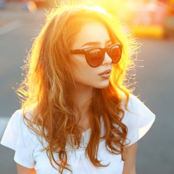 Beautiful portrait of a pretty woman with sunglasses at sunset. photo