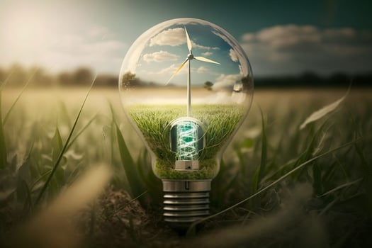 Green energy concept. Electric lightbulb and wind turbines in field. photo