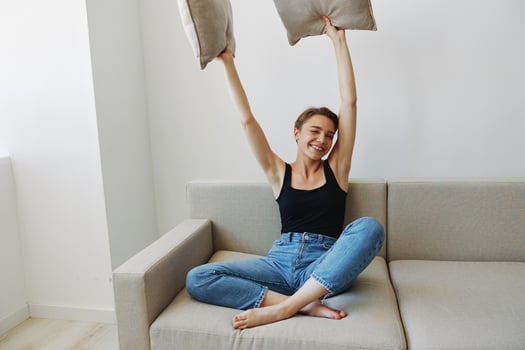 Young woman with short haircut hair having fun at home on the couch smile and happiness, vacation at home, natural posing without filters, free copy space photo