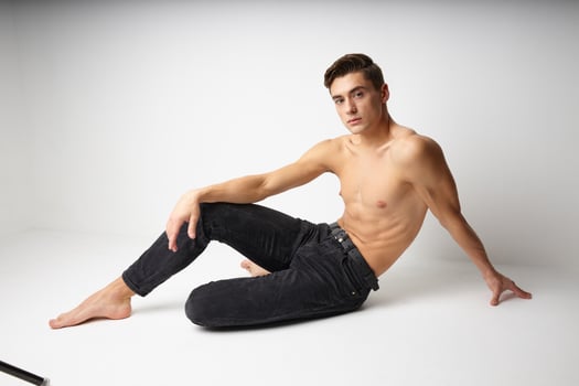 Male with naked body sitting on the floor attractive studio look isolated background model photo