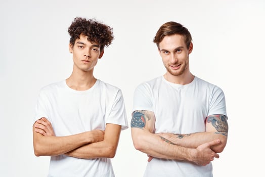 two men in white t-shirts stand side by side cropped view studio friendship photo