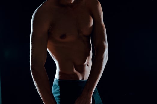 man with muscular abs cropped view of gym dark background photo