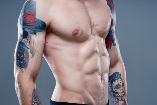 sexy athlete with naked torso and pumped up muscles tattoo gray background model photo