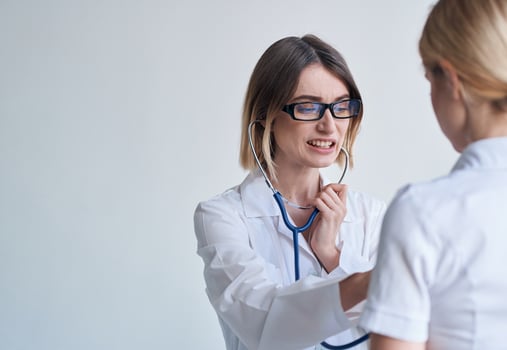 professional woman doctor in medical gown and glasses blue stethoscope patient photo