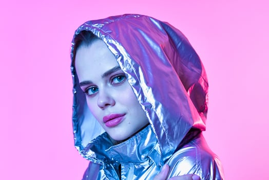 attractive woman silver hooded jacket makeup pink background neon photo