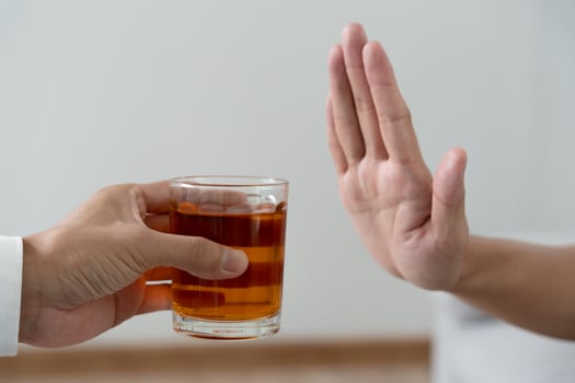 man refuses say no and avoid to drink an alcohol whiskey , stopping hand sign male, alcoholism treatment, alcohol addiction, quit booze, Stop Drinking Alcohol. Refuse Glass liquor, unhealthy, reject photo