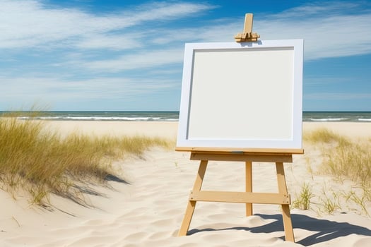 White blank artist frame on a small wooden easel on summer sea beach background with copy space. Advertising mockup artboard for pictures or artwork. Painting frame template banner. photo