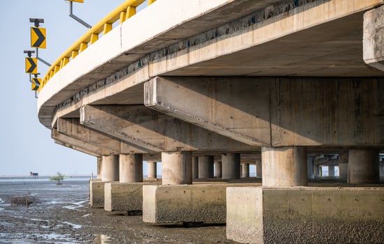 Structure of reinforced concrete bridge along the sea. Bottom view of concrete bridge. Concrete bridge engineering construction. Modern cement bridge with strong column architecture. Infrastructure. photo