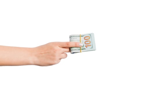Female hand giving a bundle of dollar bills on white isolated background. Power and wealth concept photo