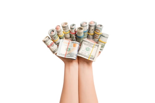 Isolated image of rolled up dollar banknotes on female fingers. Profit concept photo