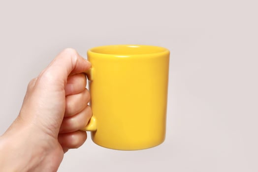 Hand holding yellow mug photo