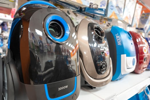 colored household vacuum cleaners on a supermarket shelf photo