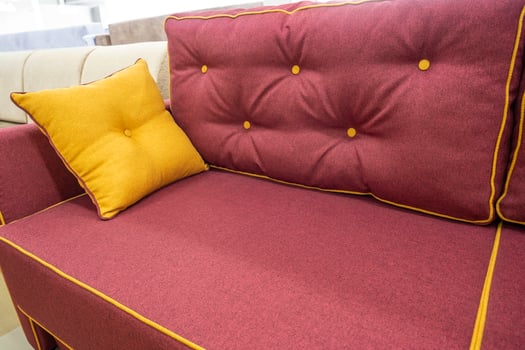 A soft new burgundy sofa with a decorative pillow photo