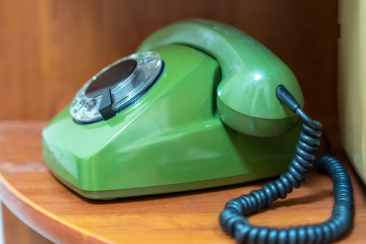 green vintage phone with a rotating dial dial. the phone on the shelf photo