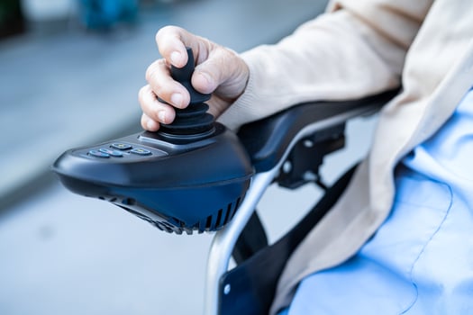 Asian senior woman patient on electric wheelchair with joystick and remote control at hospital. photo