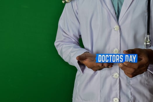 doctor standing on Green background. Hold the Doctors Day paper text. Medical and healthcare concept. photo