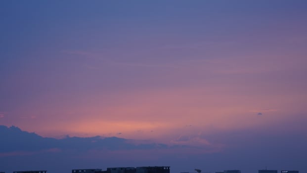 The beautiful sunset view with the buildings' silhouette and orange color sky as background in the city photo