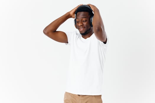 man of african appearance with closed eyes in headphones listening to music photo