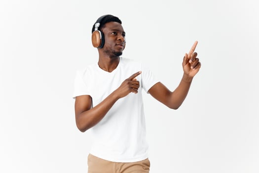 man african appearance in white t-shirt listening to music wireless headphones photo