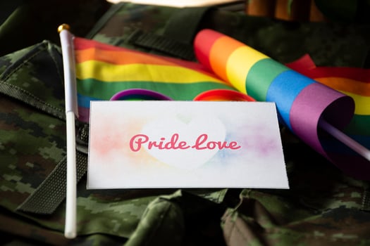 Pride Love card on camouflage backpack of soldier, concept for calling out to respect gender diversity and to invite all people to enjoy LGBTQ events around the world in pride month. photo