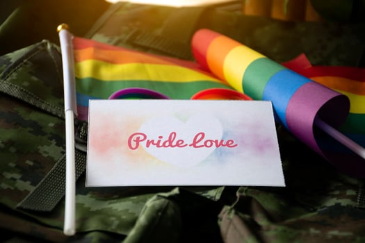 Pride Love card on camouflage backpack of soldier, concept for calling out to respect gender diversity and to invite all people to enjoy LGBTQ events around the world in pride month. photo