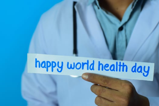 Doctor holding a card with text happy world health day. Medical and healthcare concept. photo