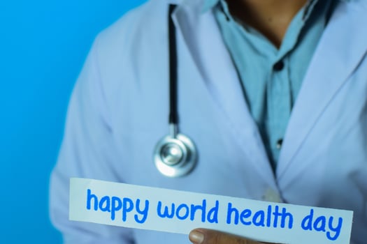Doctor holding a card with text happy world health day. Medical and healthcare concept. photo