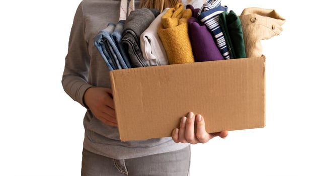Woman packs clothes in boxes for donating. photo