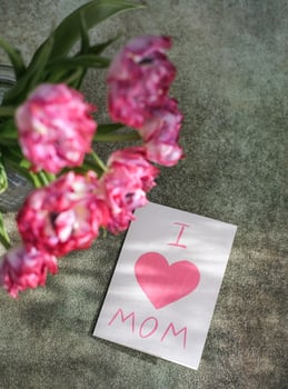 A bouquet of tulips and a card with the text I love mom. Mother's day concept photo