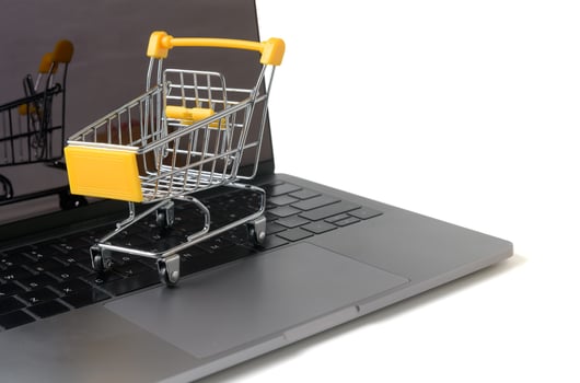 Trolley on a laptop keyboard isolated on white photo
