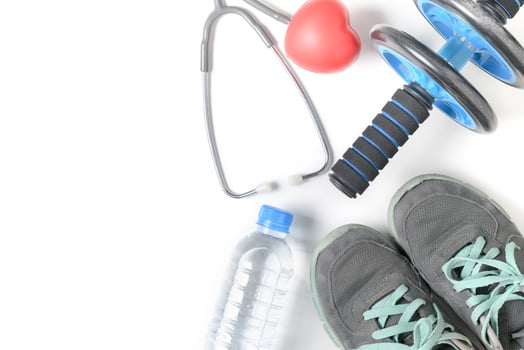 Sneakers and fitness wheel with stethoscope isolated photo