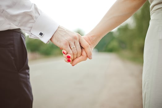 A man holds a woman's hand. Hands of the bride and groom with a wedding ring close-up photo