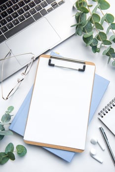 Modern white office desk table with laptop, notebook and other supplies. photo