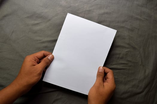 Young man hands holding blank white paper on table background photo
