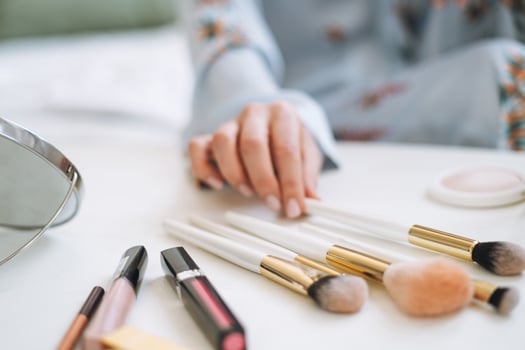 Close up photo of women's hand with makeup brushes, selective focus